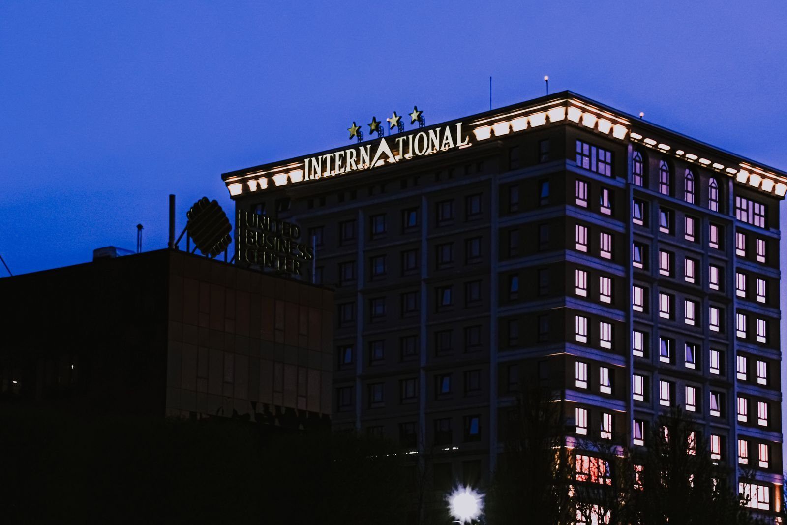 Architectural hotel facade with illuminated windows against a blue evening sky