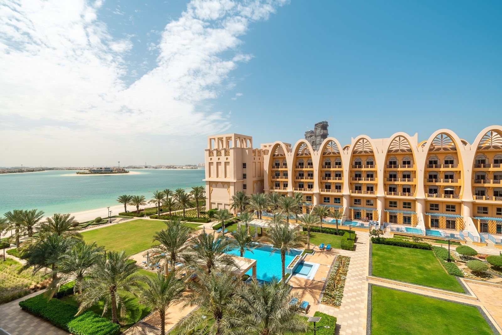 Mediterranean coastal resort with a turquoise pool, palms and warm stone architecture
